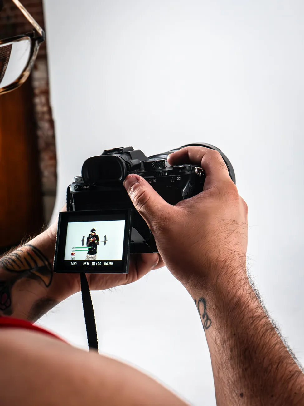 Hands framing a studio shot on a mirrorless camera