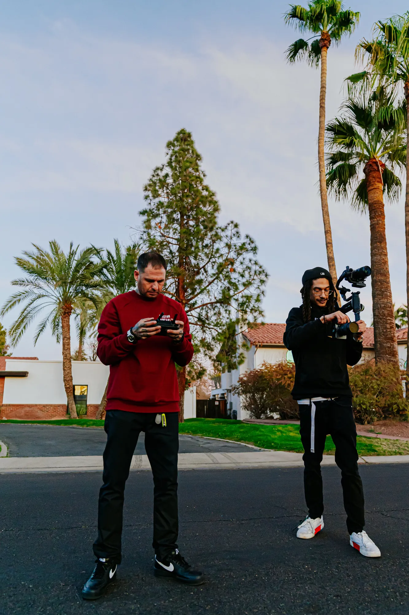 Two Elevated crew members on set with a drone controller and camera gimbal